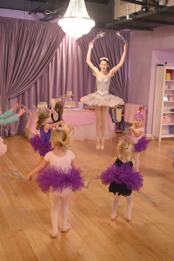 Ballet teacher jumping like 4th of July Fireworks with ballet students